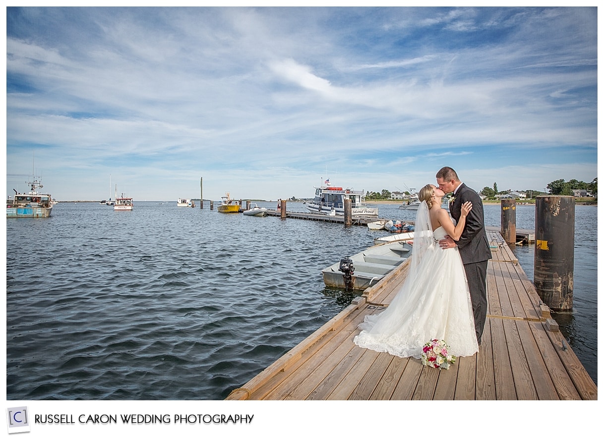 Couple kissing on dock in Pine Point Scarborough Maine, by Scarborough Maine wedding photographers Russell Caron Wedding Photography