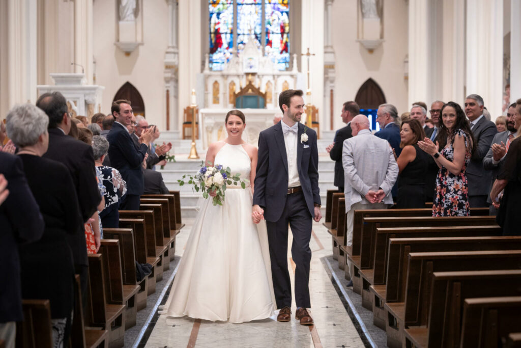 bride and groom recess down the aisle at their cathedral wedding